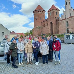 Zdjęcie grupowe. Na pierwszym planie stoją podróżnicy. Gruppenfoto. Im Vordergrund stehen die Reidenden.